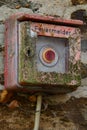 Unneeded old fire alarm box with lichen and rust Royalty Free Stock Photo