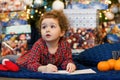 Unny pensive little girl writing letter to santa. kid making a wish, gift, present on new year eve.