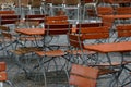 Unoccupied chairs and tables in a garden restaurant with table legs and chair legs made of iron and wooden tops Royalty Free Stock Photo