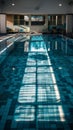 An unoccupied indoor pool basks in the quiet of the day, with rows of empty chairs and a reflection of windows casting a Royalty Free Stock Photo