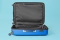 Open empty suitcase on color background