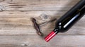 Unopen bottle of red wine with vintage corkscrew on rustic wooden boards