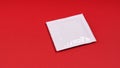 unopened white condom packet on red background with copy space Royalty Free Stock Photo