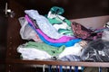 Unorganized heaps of clothes of different colors in a wardrobe lying in mess, storage and order at home