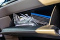 Unorganized mess inside an open glove compartment of a vehicle