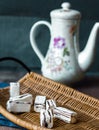 Unpacked candy in a wooden basket, tea