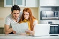 Family managing budget, reviewing their bank accounts using laptop in kitchen Royalty Free Stock Photo