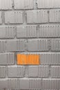 Unpainted brick of wall, one orange rectangle between grey blocks, background
