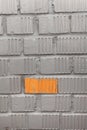 Unpainted brick of wall, one orange rectangle between grey blocks, background Royalty Free Stock Photo