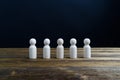 Unpainted wooden doll place align as row on black background