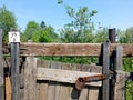 Unpainted wooden fence with a lockable door. Fence and gate cottages.