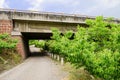 Unpaved country road crossed highway bridge below