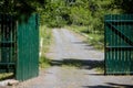 Unpaved country road leading to an open metal gate