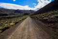Unpaved dirt mountain road under blue cloudy sky in the Canary Islands, Spain