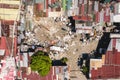 An unpaved open area littered with garbage in the center of an otherwise dense and cramped shanty town in Metro Manila