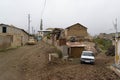 Unpaved street with cars and wooden storage for houses in the town of Hadrut part of the Janapar Trail in Nagorno Karabakh in the