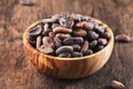 Unpeeled cocoa bean on wooden rustic background, close-up. Copy space Royalty Free Stock Photo