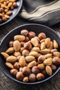 Unpeeled hazelnuts and almonds. Sweet nuts in bowl