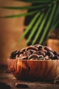 Unpeeled organic cocoa bean in bowl on wooden rustic table background. Copy space Royalty Free Stock Photo