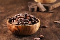 Unpeeled organic cocoa bean in bowl on wooden rustic table background. Copy space Royalty Free Stock Photo