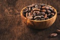 Unpeeled organic cocoa bean in bowl on wooden rustic table background. Copy space Royalty Free Stock Photo