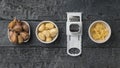 Unpeeled, peeled and grated garlic and hand grater on a wooden table