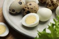 Unpeeled and peeled hard boiled quail eggs on plate, closeup Royalty Free Stock Photo