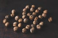 Unpeeled walnuts scattered around on the dark background