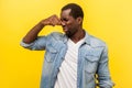 Unpleasant smell. Portrait of young man grimacing in disgust and pinching his nose. studio shot isolated on yellow background