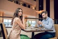 A couple sitting at the table in the restaurant and woman looking unpleased