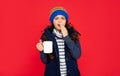 unpleased teen girl drink hot tea on red background. sleepy yawny child with coffee cup. Royalty Free Stock Photo