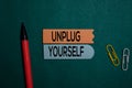 Unplug Yourself write on a sticky note isolated on Office Desk