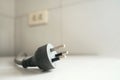 Close up of an unplugged three-prong electrical power plug on a white surface Royalty Free Stock Photo