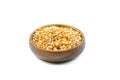 Unpopped popcorn in a wooden bowl on white background. A type of corn that expands from the kernel and puffs up when heated. Royalty Free Stock Photo