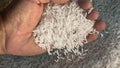 Unprocessed rice being poured from a man's hands