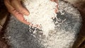Unprocessed rice being poured from a man's hands