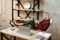 Unprofessional short-haired woman putting her legs on office table