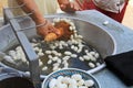 Unraveling White Silkworm Cocoons Floating in Hot Water