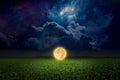 Unreal fantastic image - luminous sphere, similar to full moon, levitates over green field. Bright stars, glowing nebula and