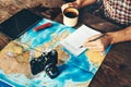 Unrecognazable Traveler Man Is Planning Vacation Travel With Map. He Drinks Coffee And Marks Royalty Free Stock Photo