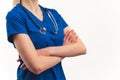 Unrecognisable female doctor in scrubs with stethoscope around neck standing confidently arms crossed close-up on torso Royalty Free Stock Photo