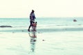 Unrecognisable hipster girl walking her dog, Greyhound, on the beach. Royalty Free Stock Photo