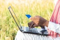 Unrecognisable Indian farmer on laptop doing payment by using credit card - concept of rural people using technology, internet and
