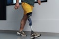 Unrecognisable male in yellow coloured shorts wearing prosthetic leg