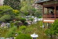 An unrecognisable man is looking at a pond of the Japanese garden of Monaco Royalty Free Stock Photo