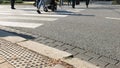 Unrecognisable pedestrians thwart the road by zebra crossing