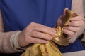 Woman cleaning brass candle sticks with a yellow duster