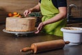 Unrecognisable woman decorating a delicious layered sponge cake with chocolate icing cream. Royalty Free Stock Photo