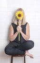 Unrecognisable woman hiding behind a sunflower Royalty Free Stock Photo