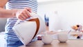 Unrecognisable woman preparing coffee or tea. Pouring water into a cup. Royalty Free Stock Photo